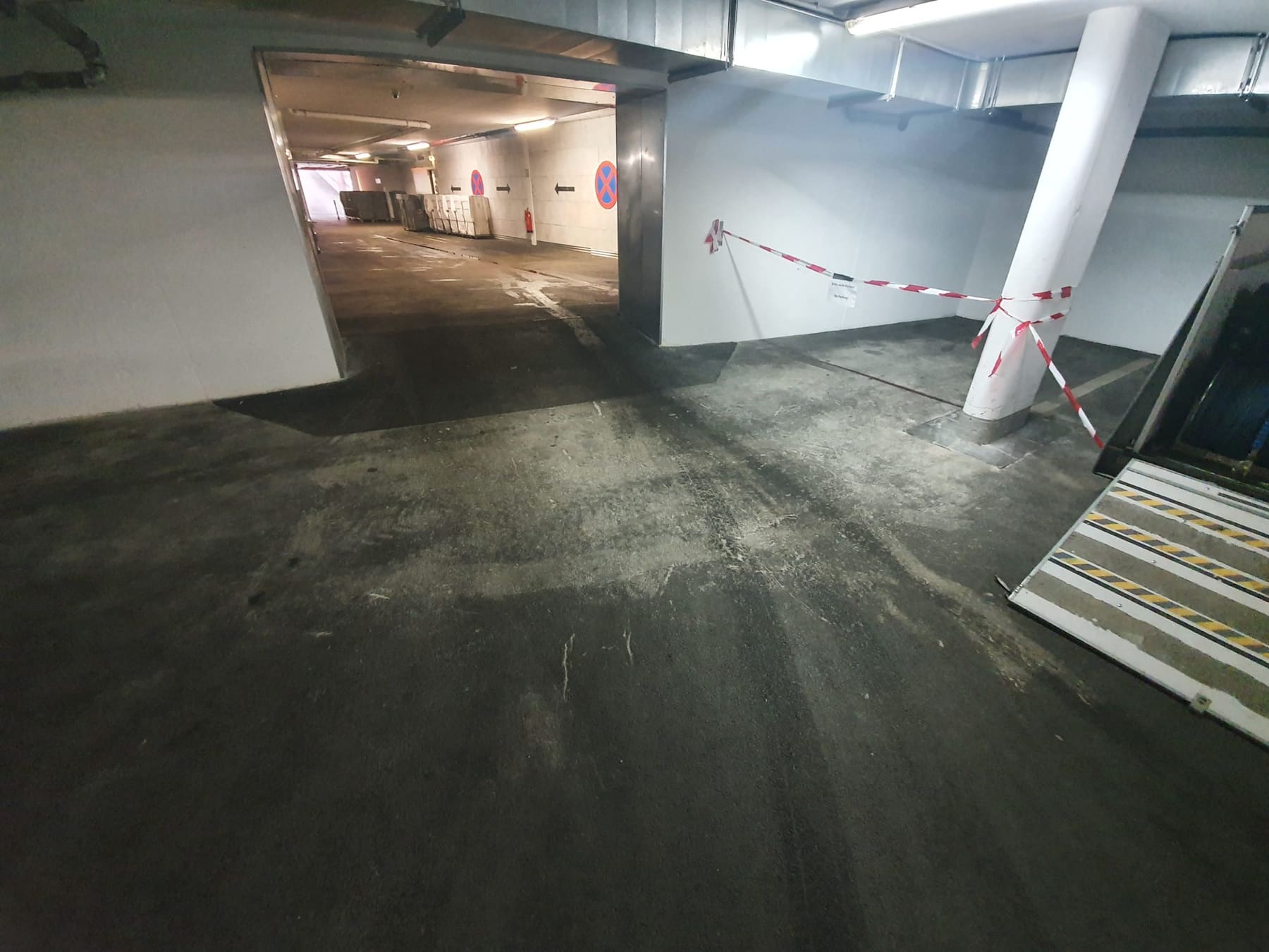 Tiefgaragenboden mit flächigem Bauschmutz vor der Reinigung.