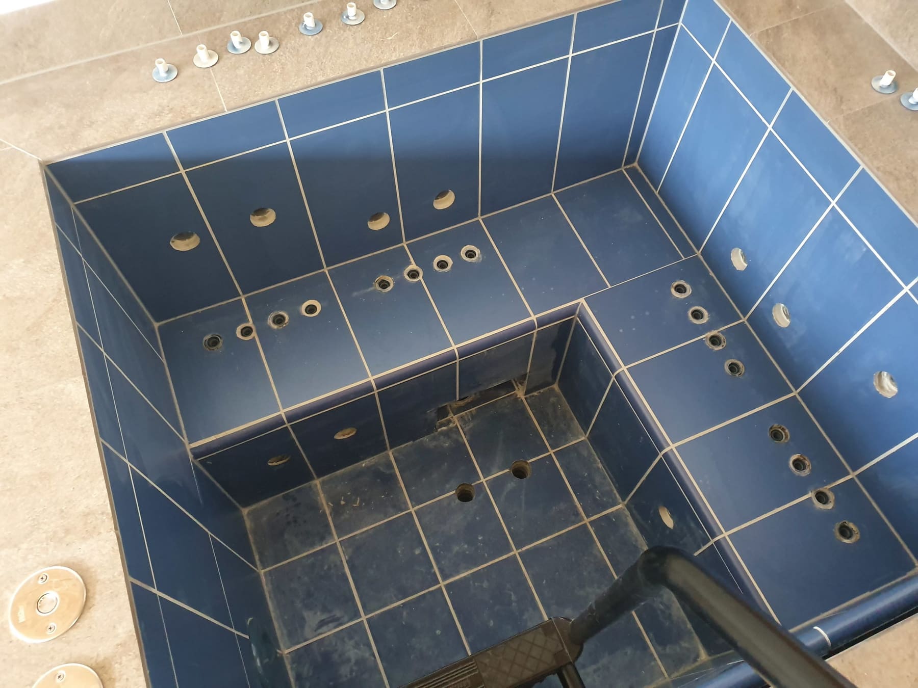 Blau gefliestes Whirlpoolbecken mit Epoxidschleier auf Fliesen und Fugen.