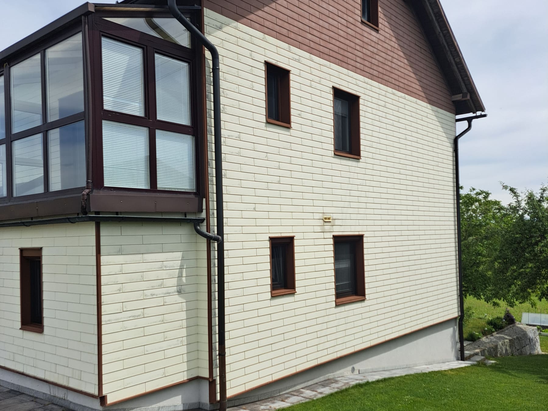 Dieselbe Faserzementfassade nach der Reinigung, gleichmäßig hell und ohne Ablagerungen.