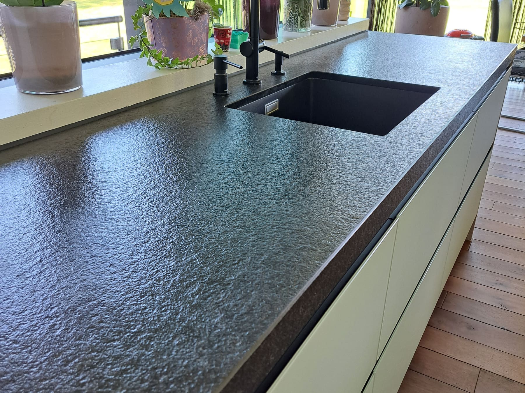 Dunkle Küchenarbeitsplatte aus Granit nach Reinigung und Imprägnierung, mit geschlossener Oberfläche.
