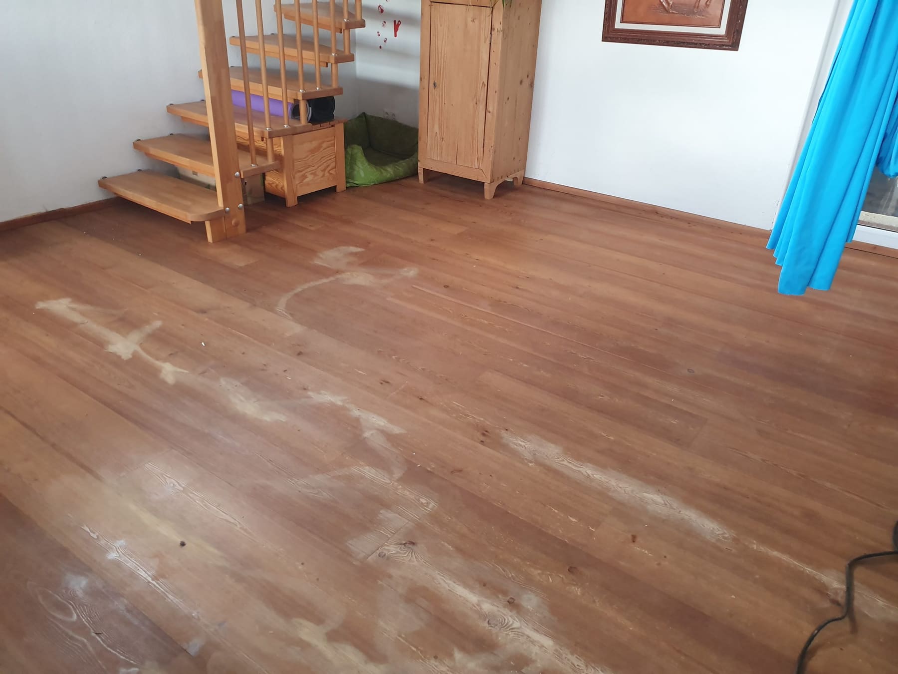 Dielenboden aus Nadelholz während der Behandlung, mit sichtbaren Bearbeitungsspuren.
